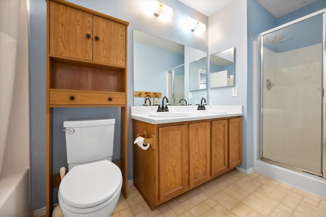 bathroom with double vanity, a sink, toilet, and a shower stall