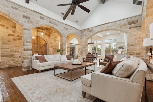 living area with arched walkways, visible vents, high vaulted ceiling, beamed ceiling, and hardwood / wood-style flooring