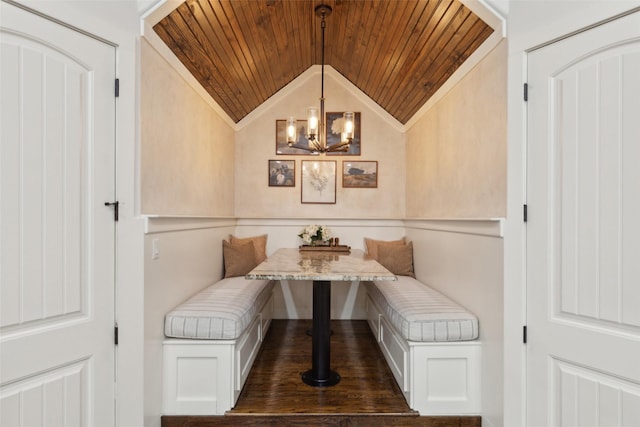 dining area with breakfast area, lofted ceiling, wooden ceiling, and a notable chandelier