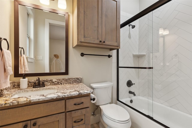 bathroom with toilet, shower / bath combination with glass door, and vanity