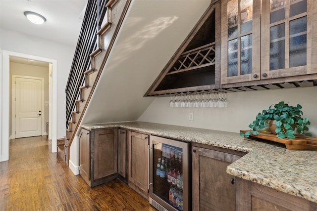 bar featuring wine cooler, dark wood-style flooring, a bar, and stairs