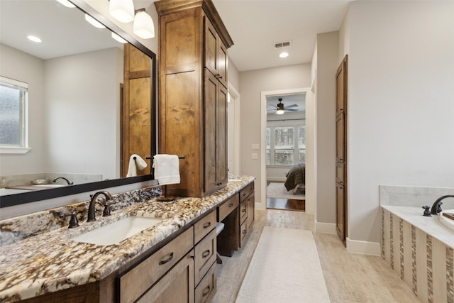 full bath with baseboards, visible vents, connected bathroom, vanity, and a bath