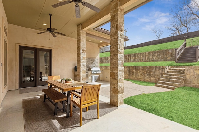 view of patio / terrace featuring french doors, stairway, an outdoor kitchen, outdoor dining space, and fence