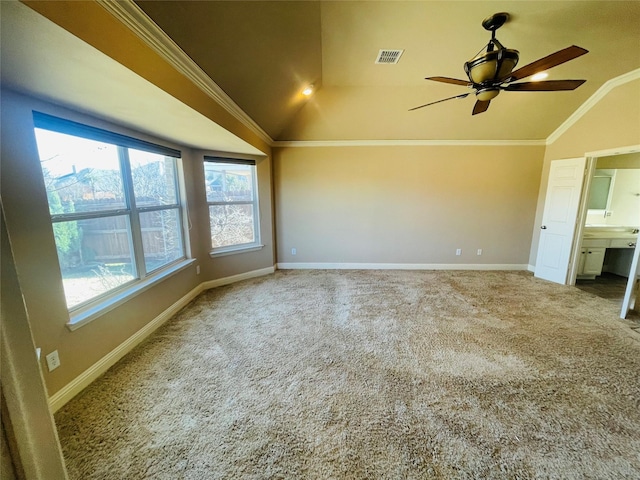 carpeted spare room featuring baseboards, visible vents, a ceiling fan, lofted ceiling, and crown molding