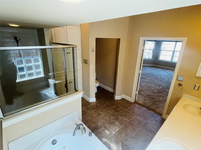 bathroom with toilet, a sink, a shower stall, a whirlpool tub, and tile patterned floors