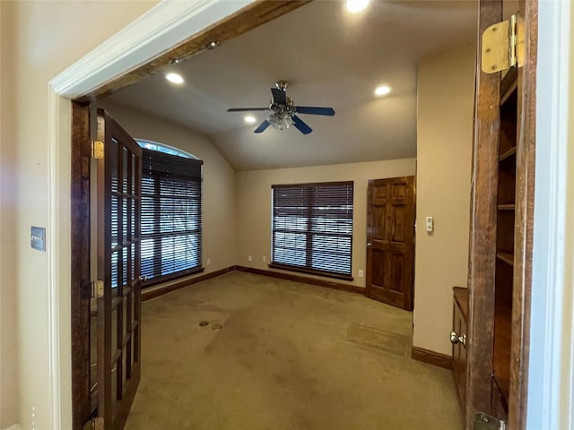 foyer entrance featuring carpet, vaulted ceiling, baseboards, and ceiling fan