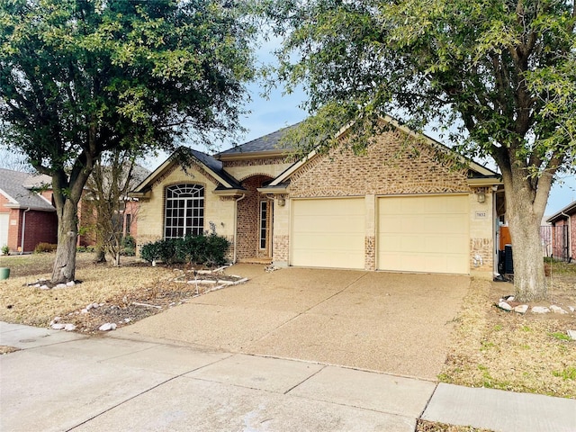 ranch-style home with a garage, brick siding, and driveway