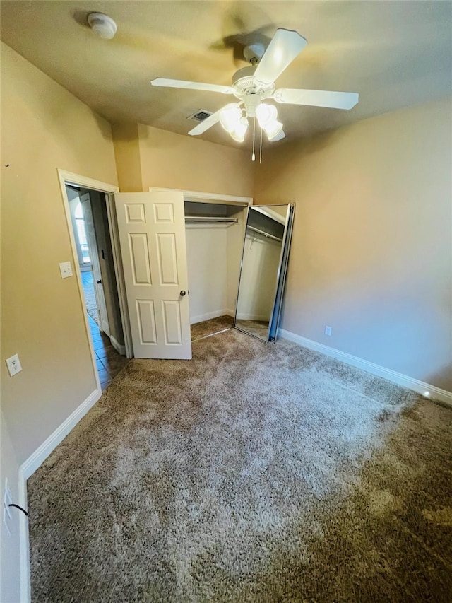 unfurnished bedroom featuring carpet, a closet, visible vents, a ceiling fan, and baseboards