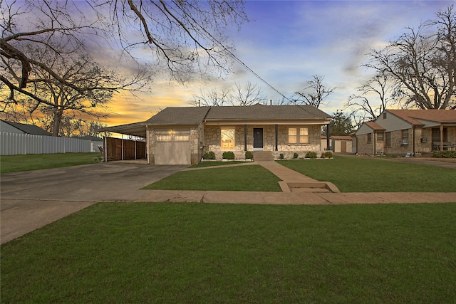 view of front of property with an attached carport, fence, concrete driveway, stone siding, and a front yard