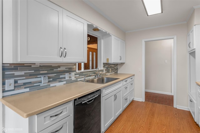 kitchen featuring black dishwasher, tasteful backsplash, light countertops, white cabinets, and a sink