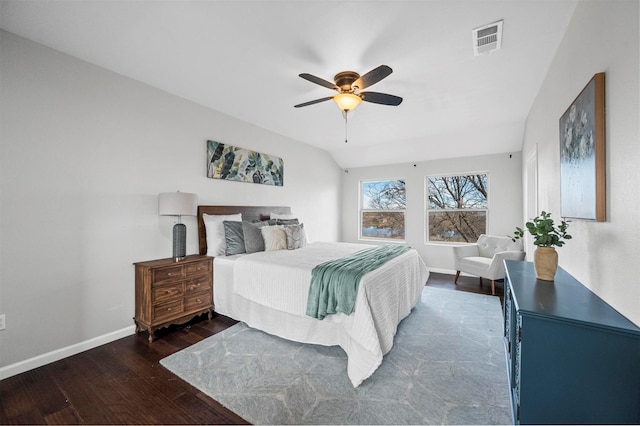 bedroom with baseboards, visible vents, vaulted ceiling, and wood finished floors