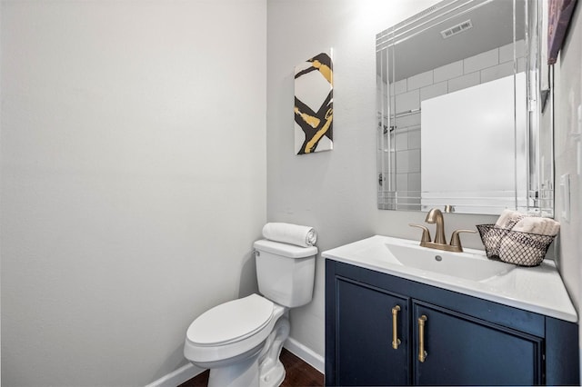 bathroom with toilet, baseboards, visible vents, and vanity