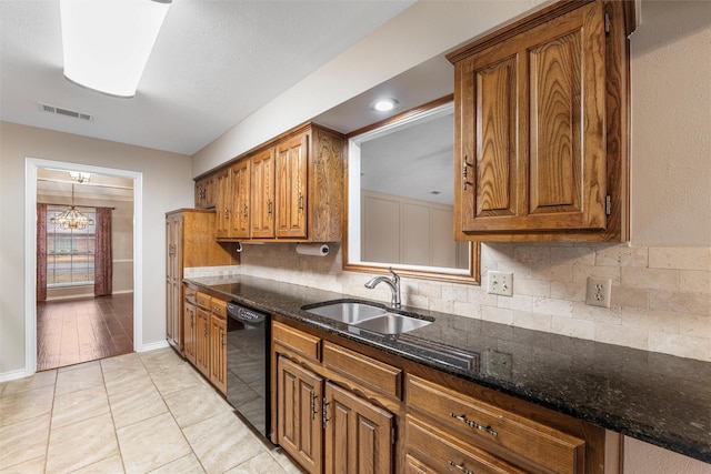 kitchen with black dishwasher, tasteful backsplash, brown cabinetry, and a sink