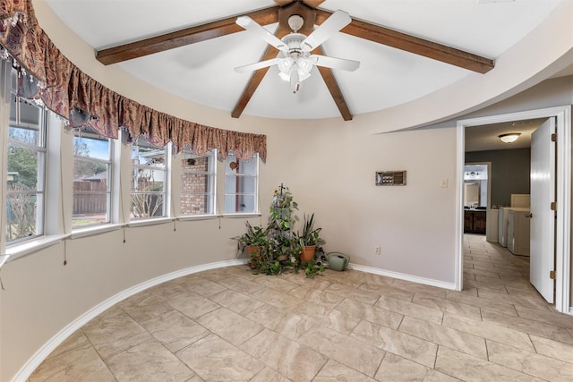 empty room featuring vaulted ceiling with beams, baseboards, washer and clothes dryer, and a ceiling fan