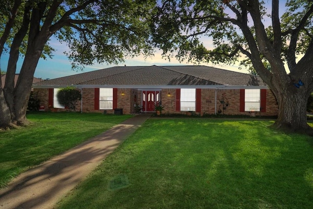 ranch-style home with brick siding and a yard