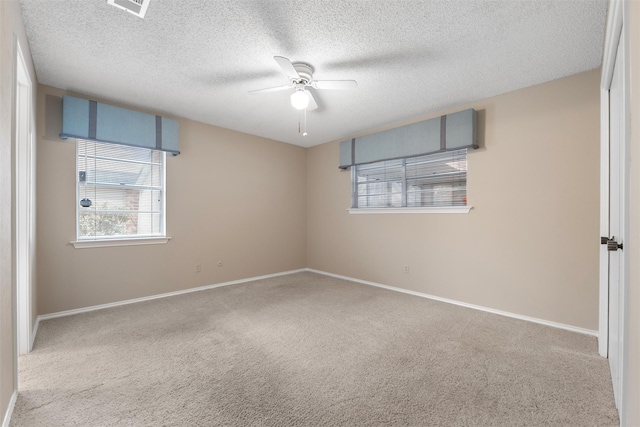 unfurnished room featuring carpet floors, a ceiling fan, and a wealth of natural light