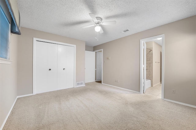 unfurnished bedroom with carpet floors, a closet, visible vents, and a textured ceiling