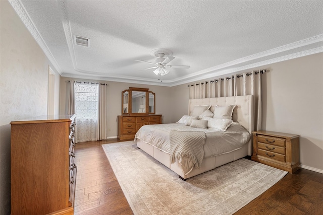 bedroom with dark wood-style flooring, visible vents, crown molding, and a textured ceiling