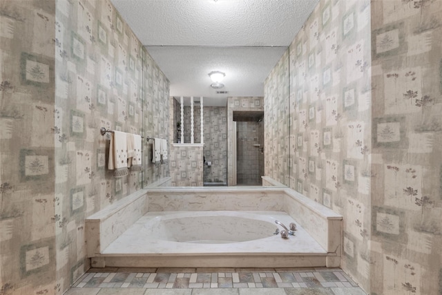 full bath with a textured ceiling and a bath