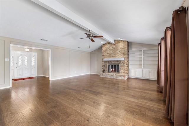 unfurnished living room featuring vaulted ceiling with beams, a decorative wall, and wood finished floors