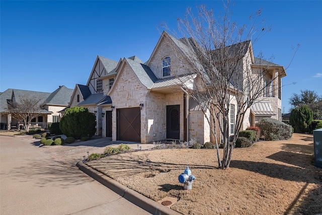 view of front of home featuring stone siding and concrete driveway