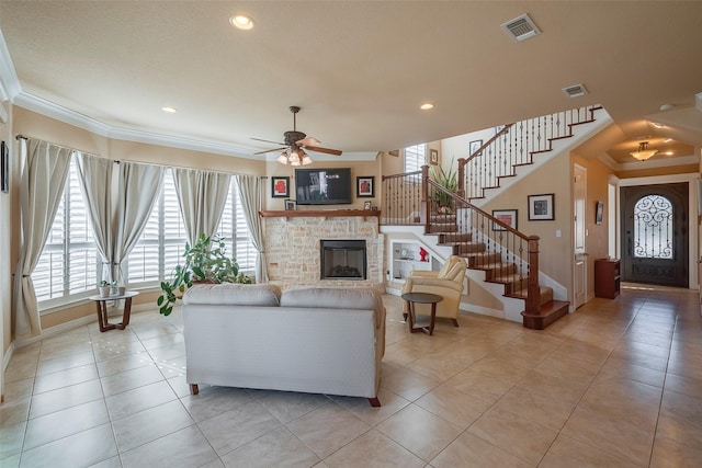 living room featuring visible vents, crown molding, and a glass covered fireplace