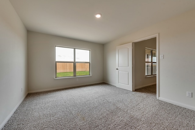 unfurnished room with carpet floors and baseboards