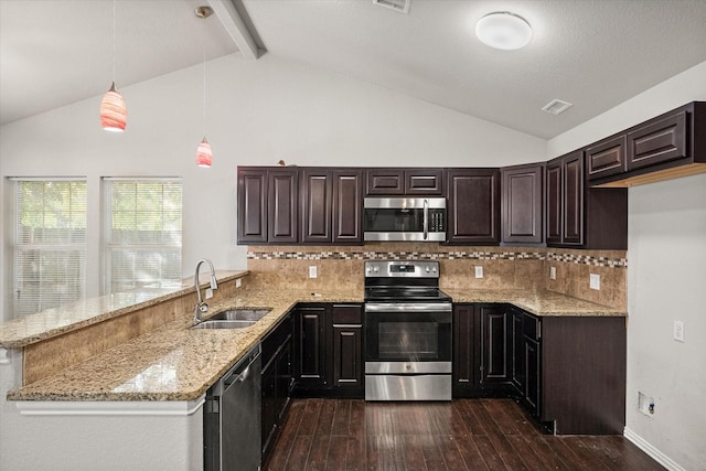 kitchen with a peninsula, a sink, appliances with stainless steel finishes, light stone countertops, and dark wood-style floors