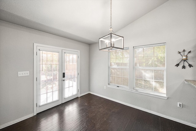 unfurnished dining area featuring lofted ceiling, baseboards, french doors, dark wood-style floors, and an inviting chandelier