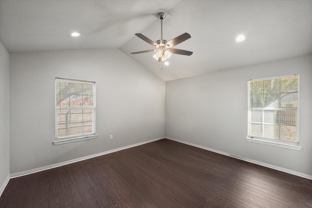 spare room featuring lofted ceiling, recessed lighting, dark wood-type flooring, a ceiling fan, and baseboards