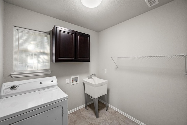 clothes washing area featuring cabinet space, visible vents, a textured ceiling, washer / dryer, and baseboards