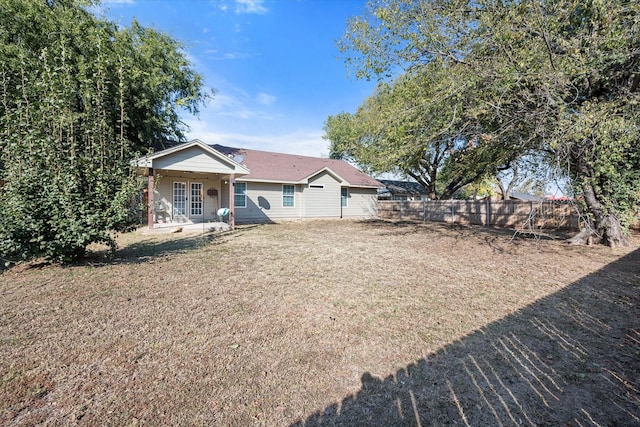 view of front of home featuring covered porch, fence, and a front lawn