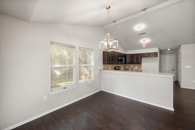 kitchen featuring visible vents, lofted ceiling, stainless steel microwave, dark wood-type flooring, and light countertops