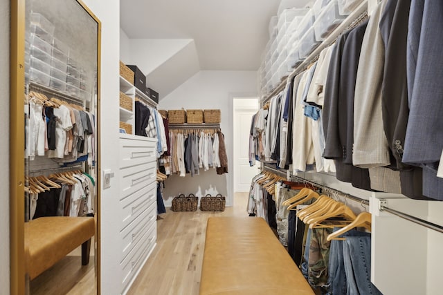 spacious closet with light wood-style floors and vaulted ceiling