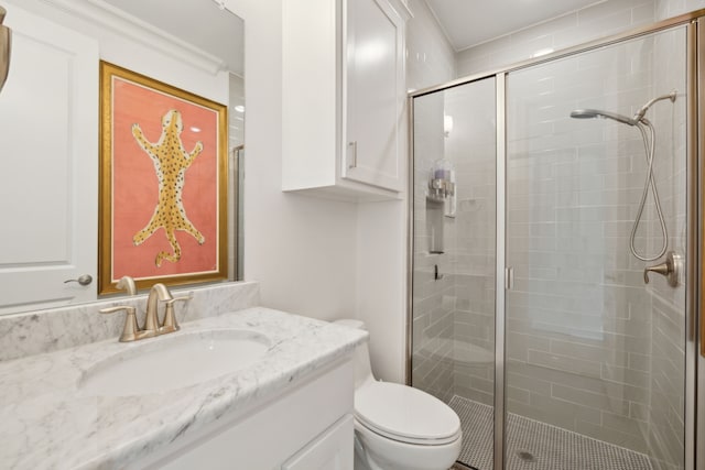 bathroom with a stall shower, vanity, and toilet