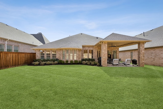 rear view of property with a patio area, brick siding, and a yard