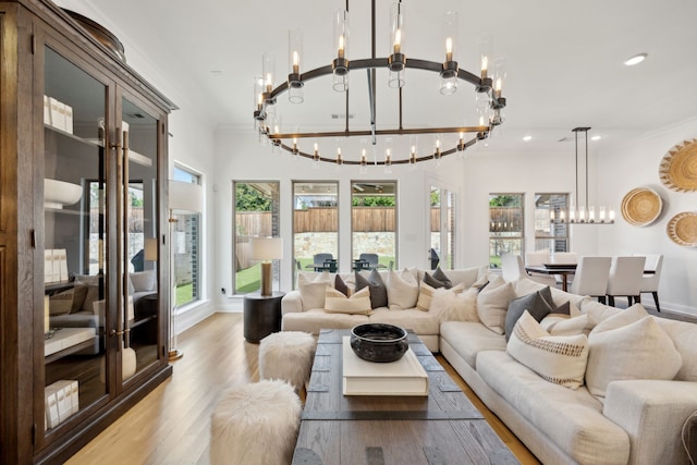 living area featuring baseboards, ornamental molding, wood finished floors, a chandelier, and recessed lighting