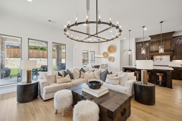 living room featuring visible vents, arched walkways, light wood-style flooring, crown molding, and recessed lighting