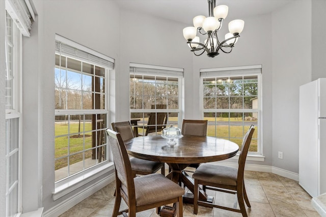 dining room with light tile patterned floors, an inviting chandelier, and baseboards