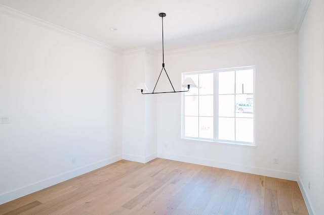 unfurnished room featuring light wood-type flooring, baseboards, and crown molding