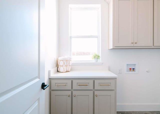 laundry area featuring hookup for a washing machine, cabinet space, and baseboards