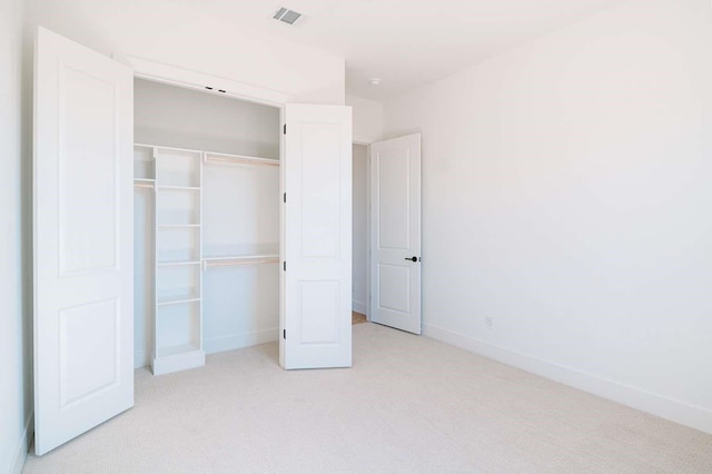 unfurnished bedroom featuring a closet, visible vents, baseboards, and carpet flooring