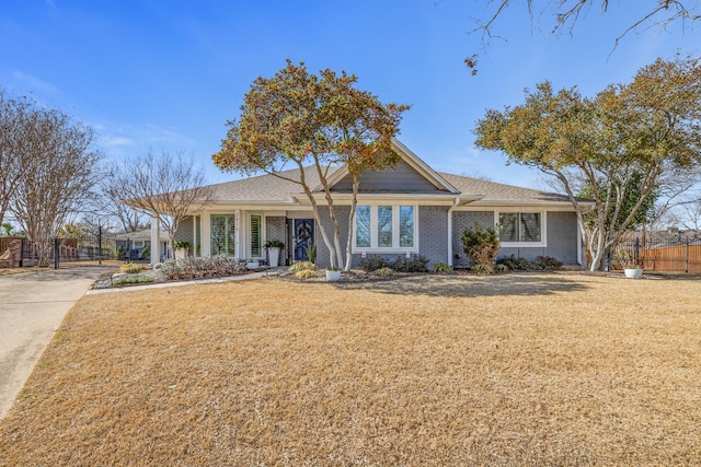 ranch-style house with brick siding, fence, and a front yard