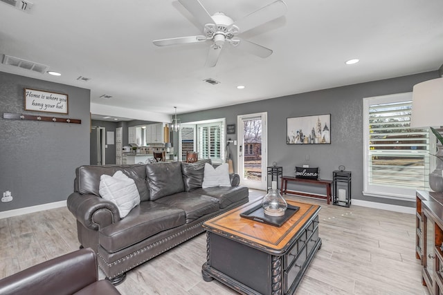 living area with visible vents, light wood finished floors, and baseboards