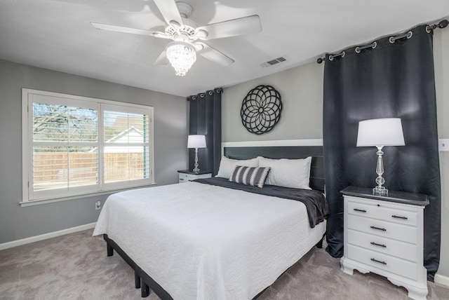 carpeted bedroom featuring baseboards, visible vents, and ceiling fan