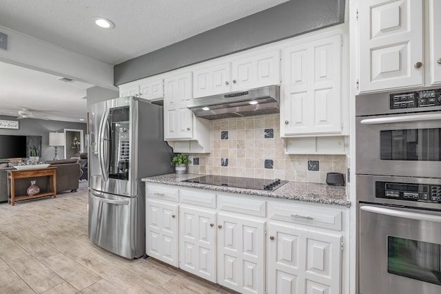 kitchen with ceiling fan, under cabinet range hood, white cabinetry, appliances with stainless steel finishes, and decorative backsplash