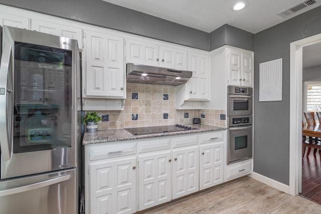 kitchen with tasteful backsplash, visible vents, white cabinets, appliances with stainless steel finishes, and under cabinet range hood