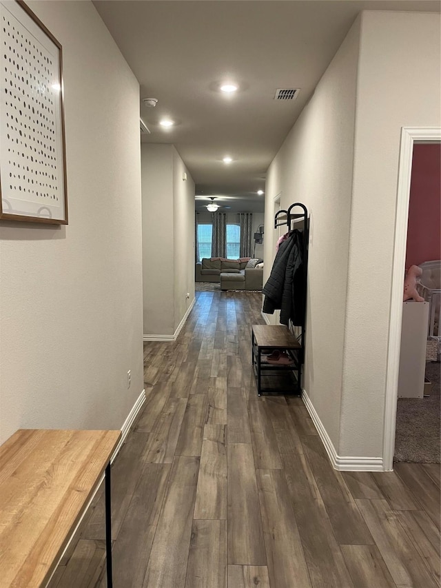 corridor with recessed lighting, visible vents, dark wood finished floors, and baseboards