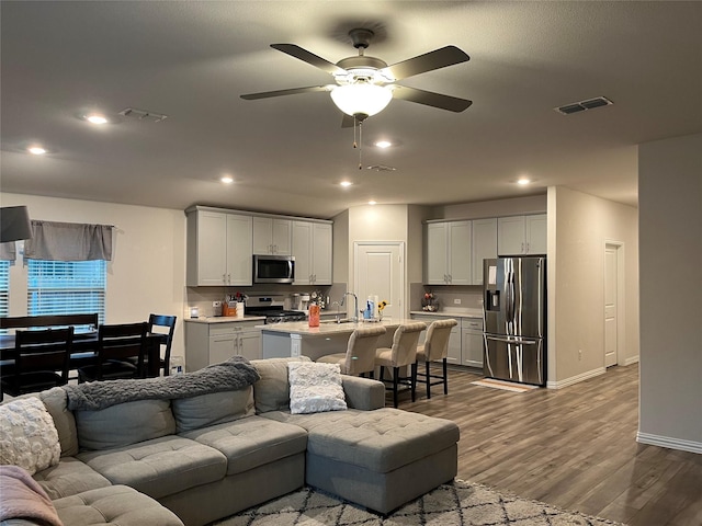 living area with visible vents, recessed lighting, a ceiling fan, and dark wood-style flooring