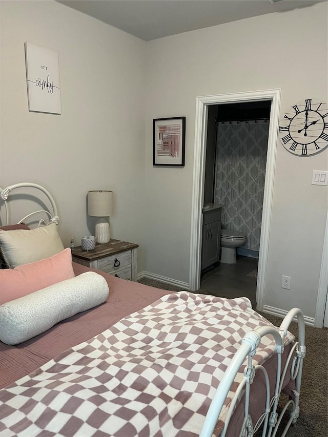 bedroom featuring ensuite bath, baseboards, and dark colored carpet